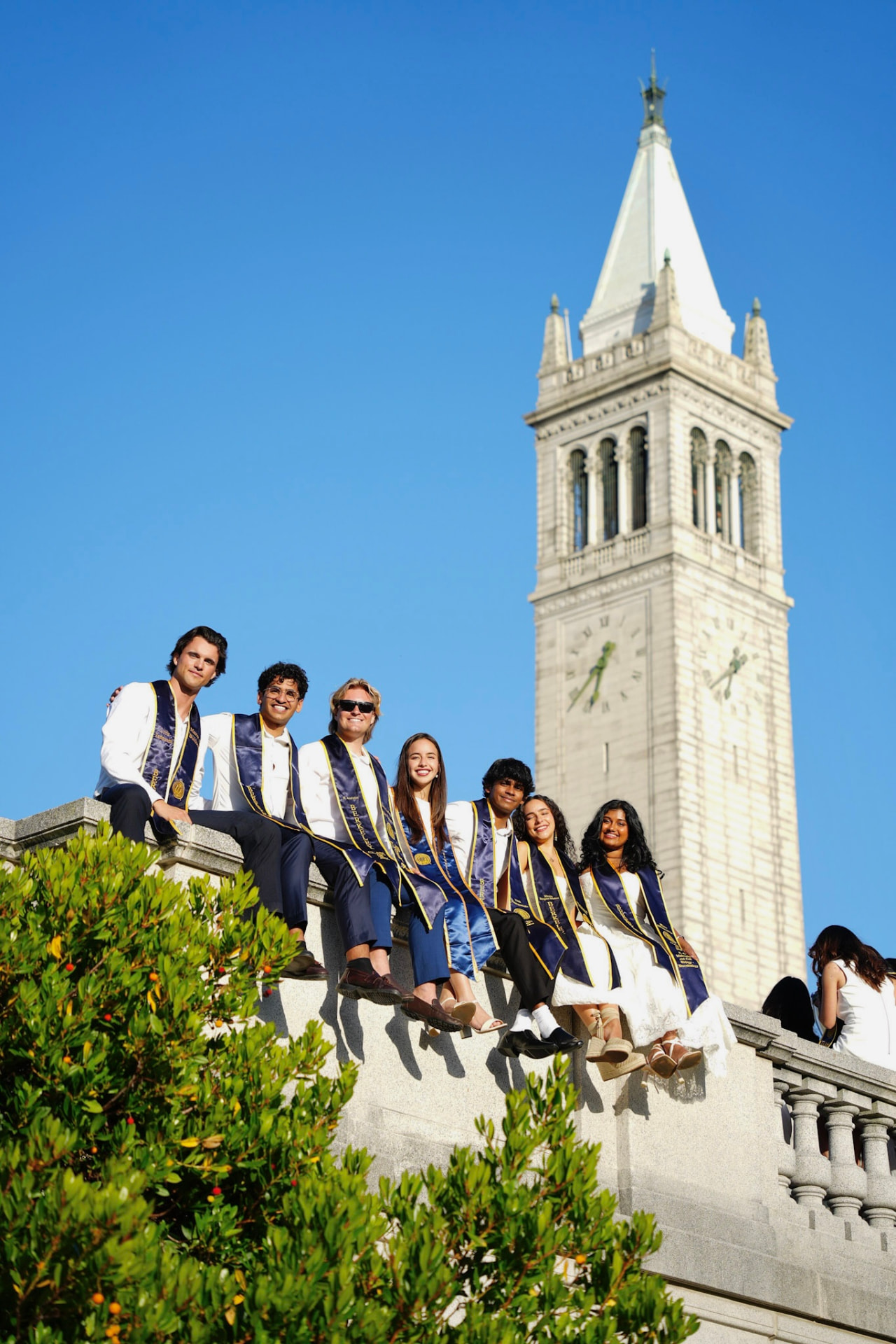 ISAB members in Berkeley graduation stoles seated in front of the Campanile